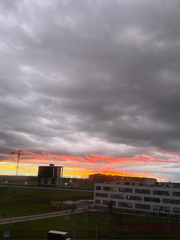 Dramatic sunset illuminates city skyline with vibrant orange clouds