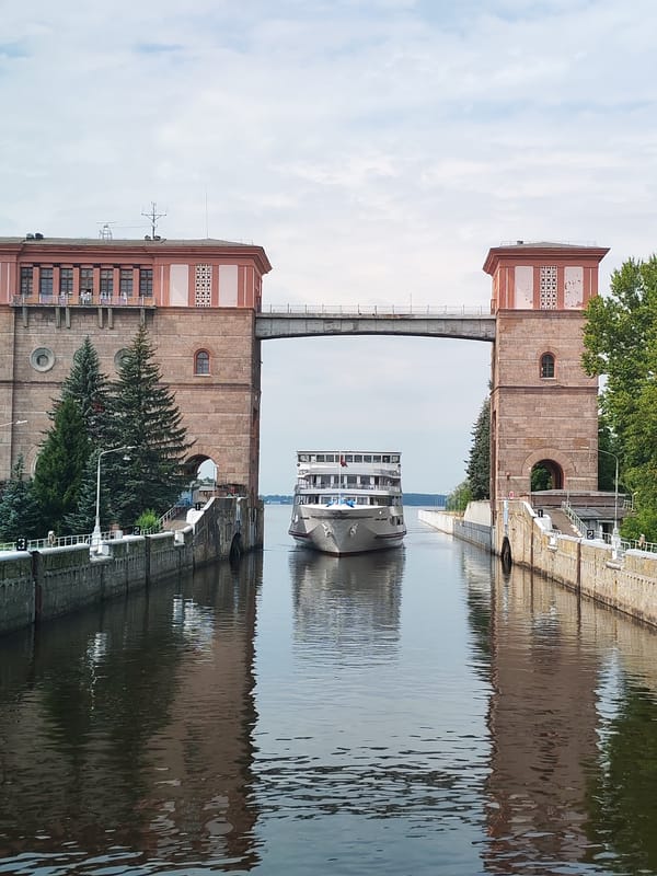River cruise ship passes through a brick lock on a Russian canal.
