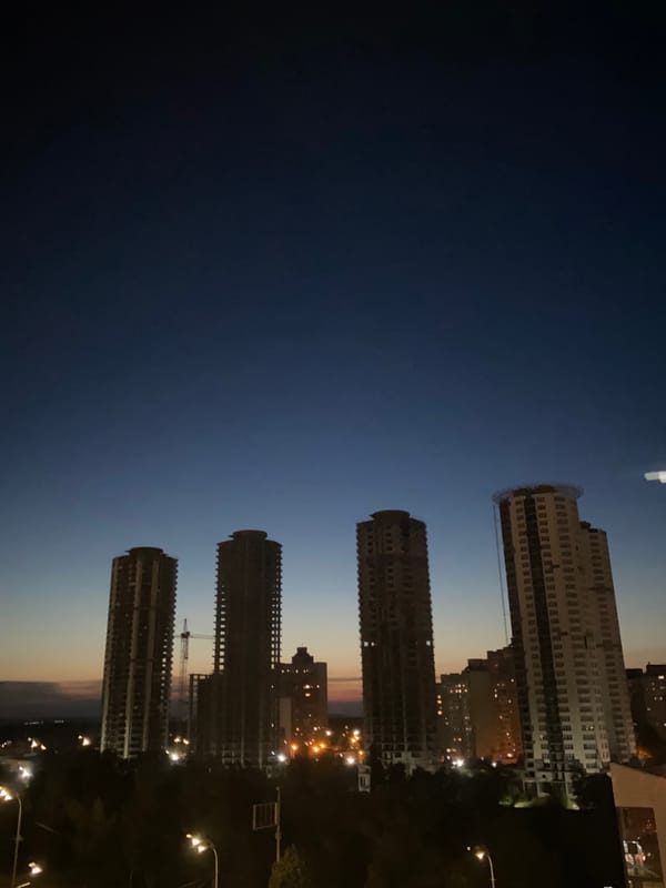 Unfinished skyscrapers cut into a city's golden hour sky