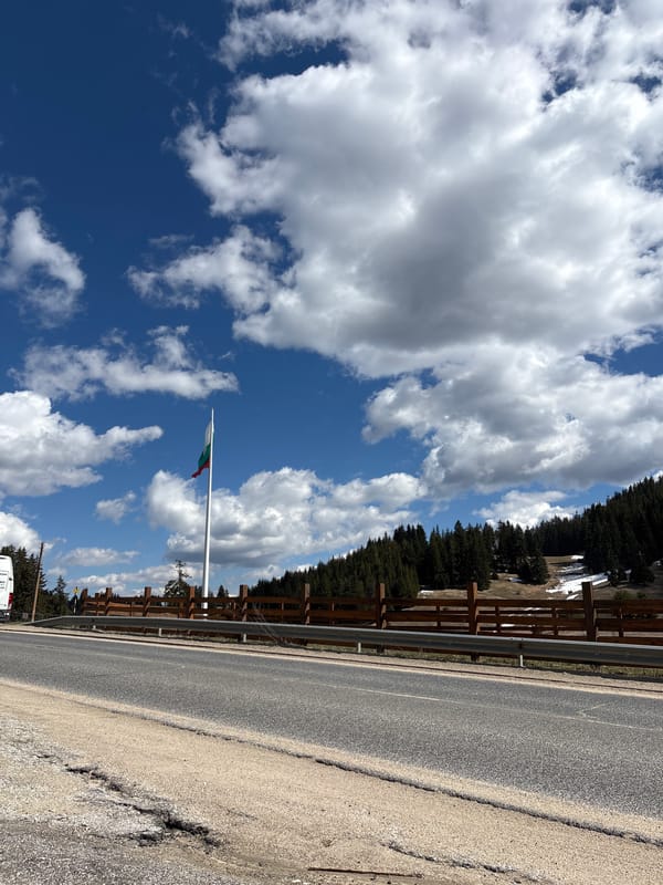 Bulgarian flag flies on flagpole in Smolyan landscape
