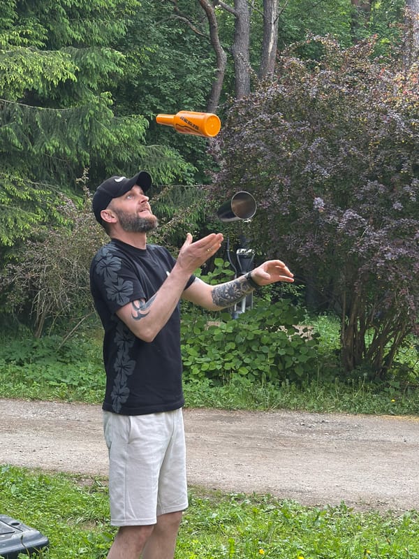 Man juggles bottle and cup in Tallinn park