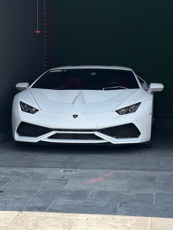 White Lamborghini displayed near modern buildings in Mexican town
