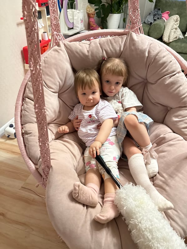 Children rest together in hanging chair in Russian playroom