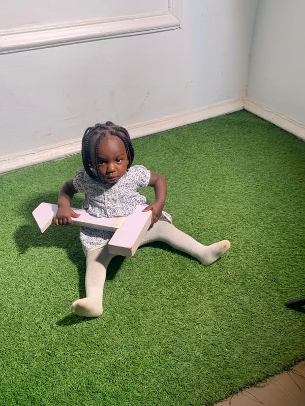 Child plays with numbers indoors while soccer games unfold outdoors