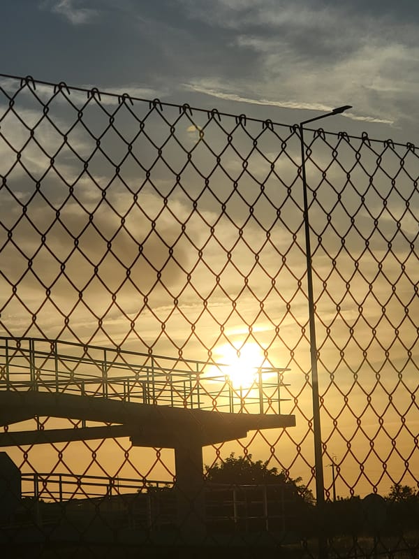 Sunset through a chain-link fence near Faro, Portugal