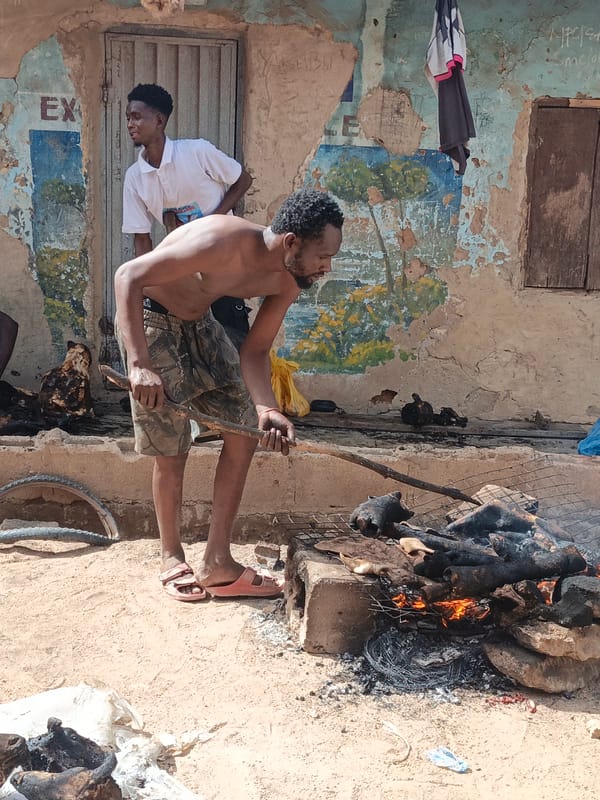 Men grill meat over open fires in Gwagwarwa, Nigeria