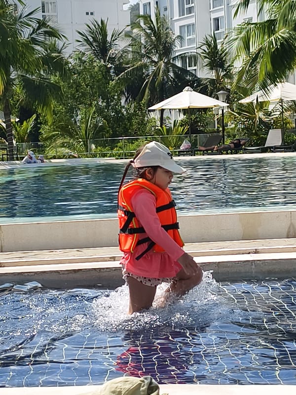 Child enters resort pool in Bac Nha Trang Ward
