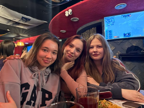 Three women socialize over drinks at Chaikovsky bar