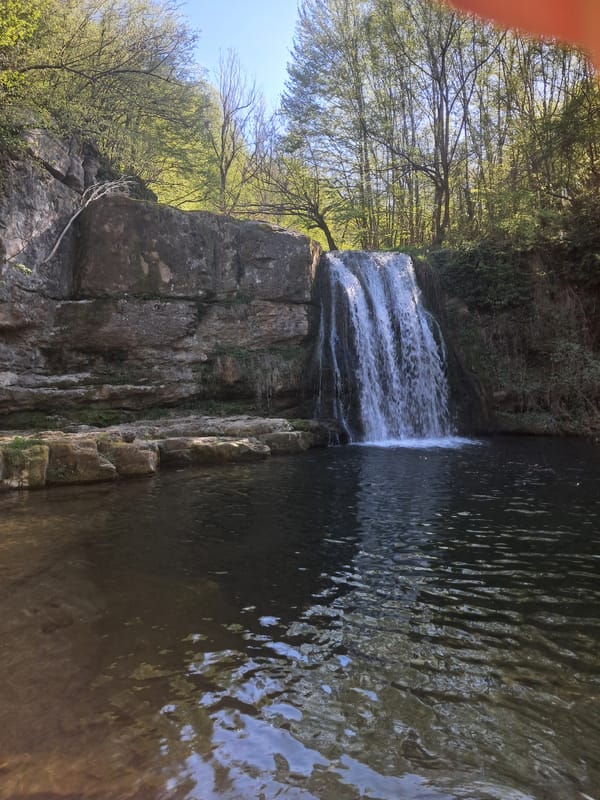 Visitor documents waterfall, wades in stream near Solari, Bulgaria