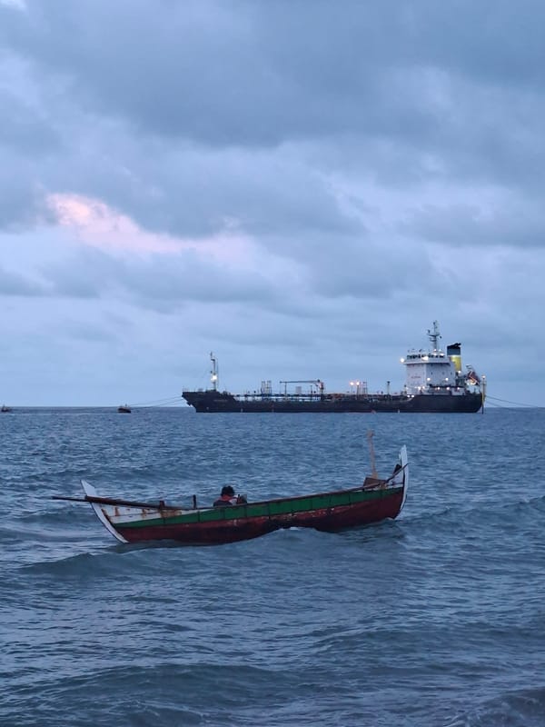 Fishing boats operate near docked tanker in Lhokseumawe port