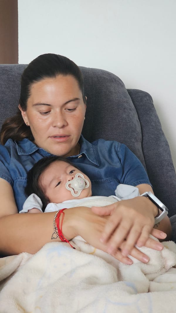 Parent cradles baby on couch in Mexican town