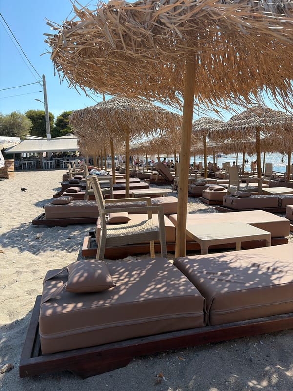Thatched umbrellas and loungers line a quiet resort beach