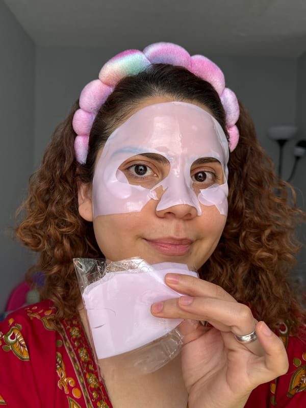 Woman applies pink face mask during afternoon skincare routine