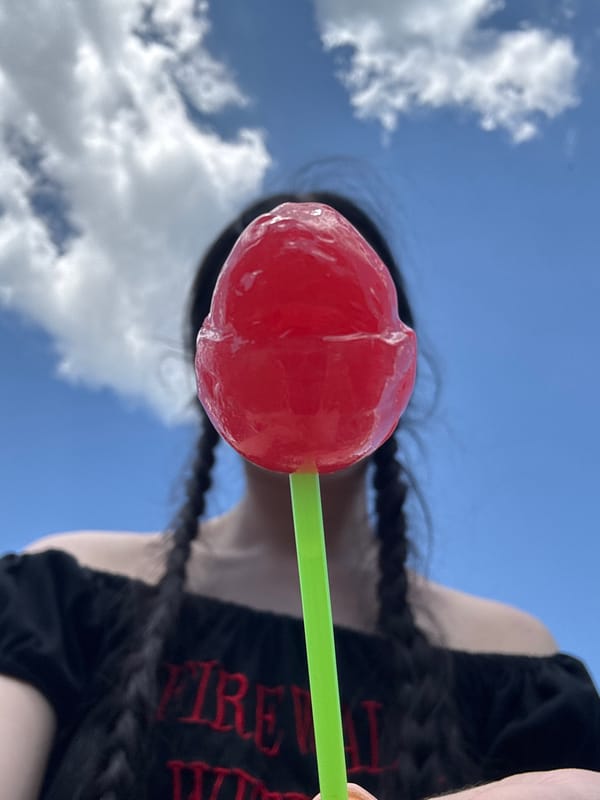Red lollipop covers a face under blue Prokopyevsk skies