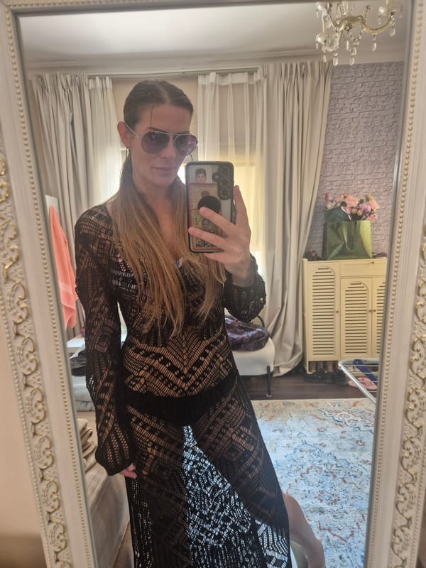 Woman takes selfie in ornate mirror amid home furnishings