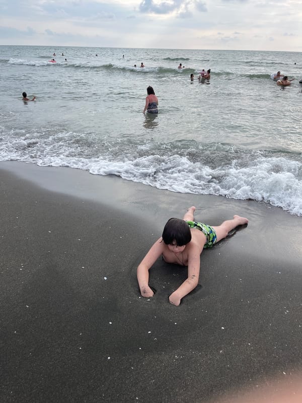 Crowded summer afternoon on Ureki's black sand beach