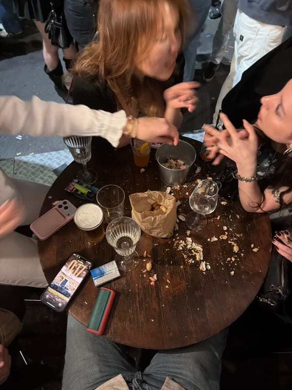 Group gathers at peanut-shell covered table in Milan bar