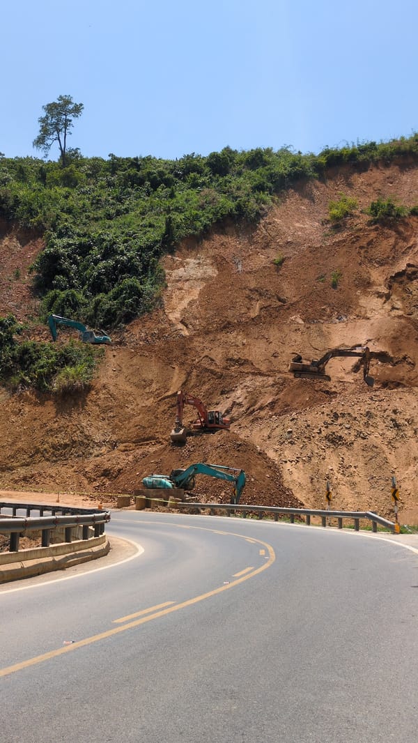 Excavators work hillside construction site in Vietnam