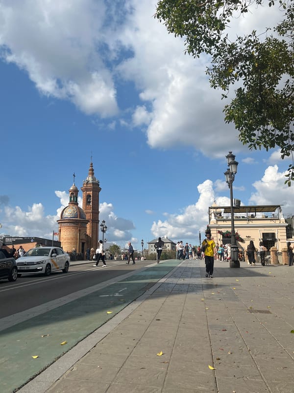 Visitor explores Plaza de España in Seville wearing fish pendant
