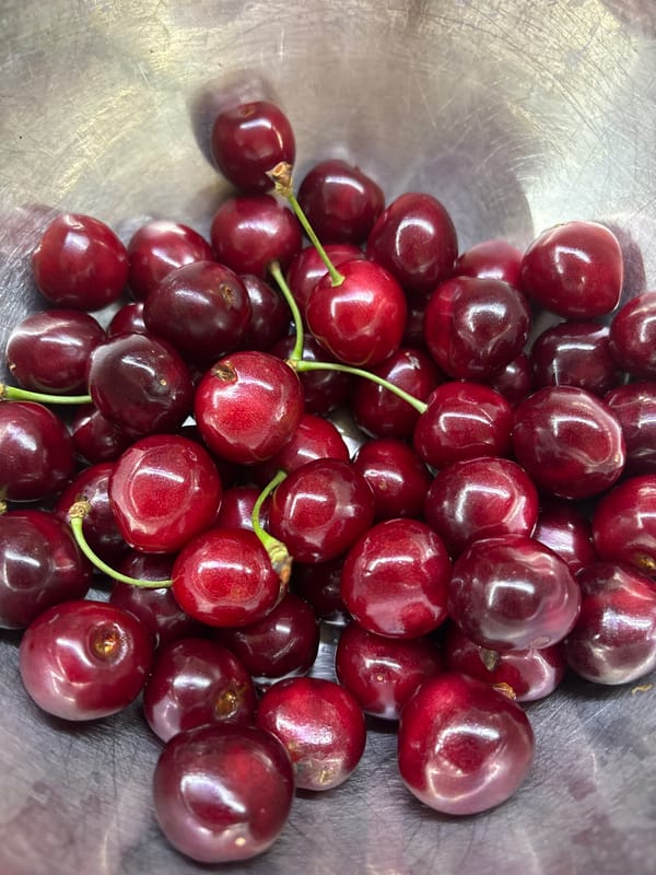 Fresh cherries, flowers, and a city window on a quiet morning