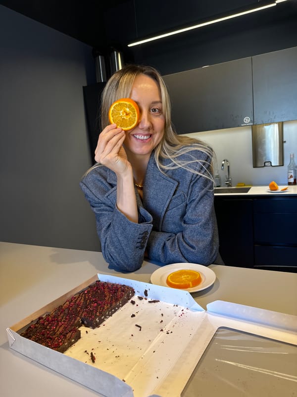 Woman playfully poses with orange slice in Riga cafe