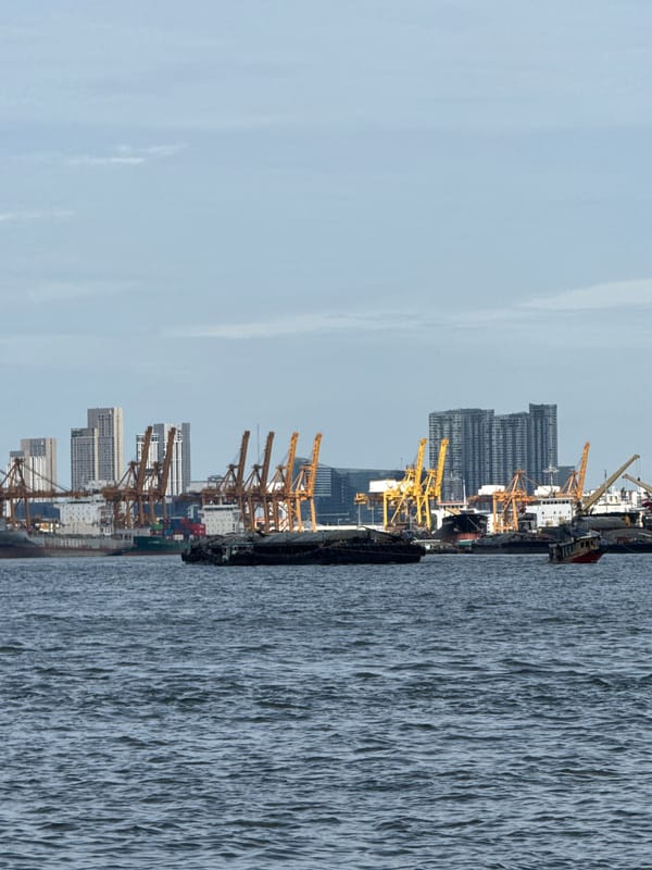 Red-hulled cargo ship transiting the Chao Phraya River, Bangkok