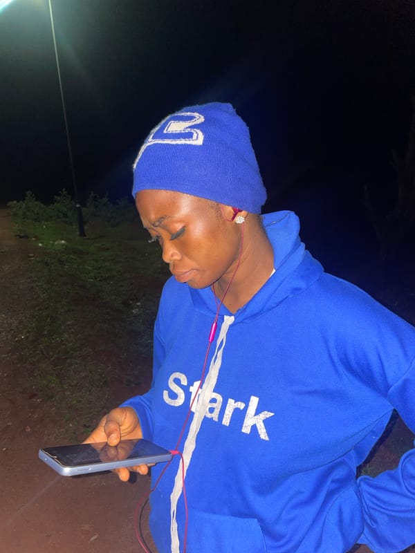 Person uses smartphone outdoors at night in Ogbe, Nigeria