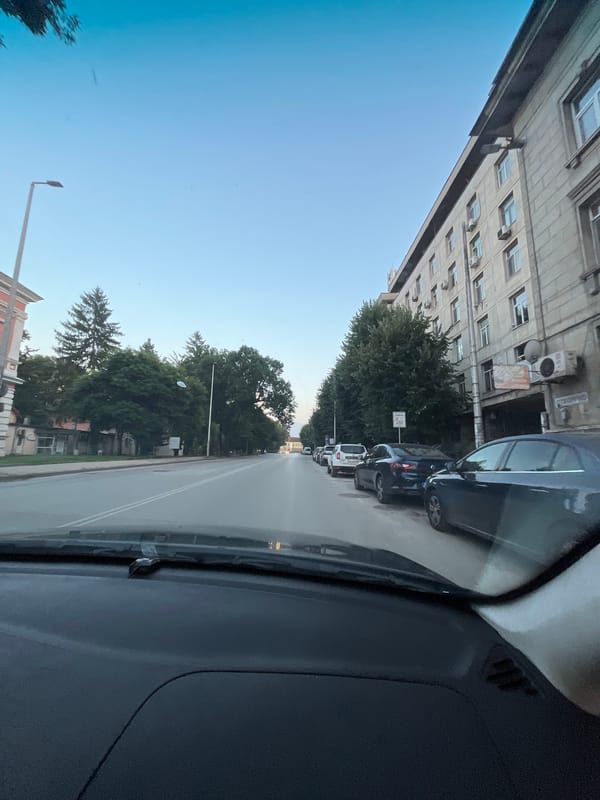 Evening drive through a city, streets and storefronts in view
