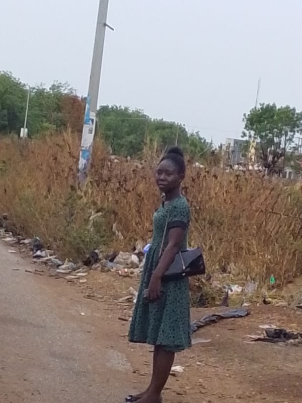 Woman stands on dirt road in Tamale, Ghana