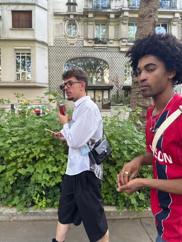 Two young men spotted on Paris sidewalk near greenery