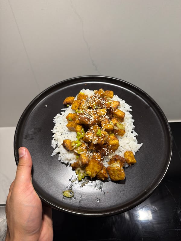 Person serves rice and glazed tofu dish in London