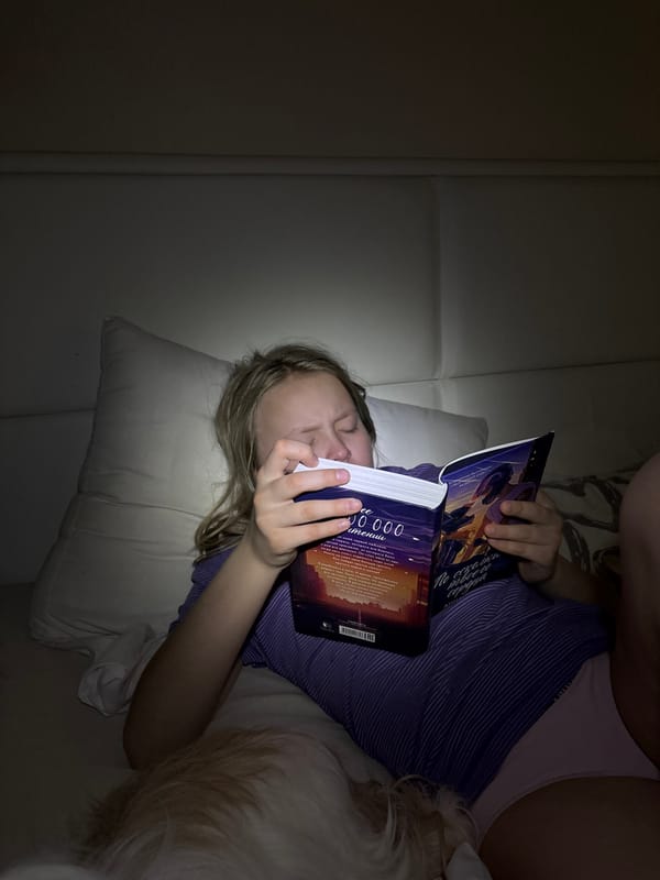 Girl reads Cyrillic book on couch in Izhevsk