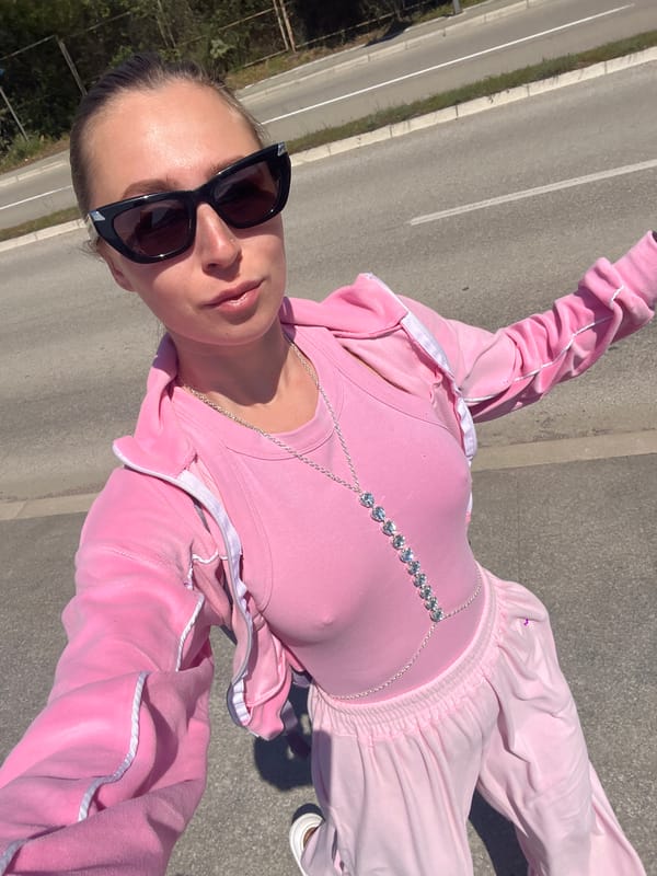 Person takes selfie on road in Montenegro wearing pink tracksuit
