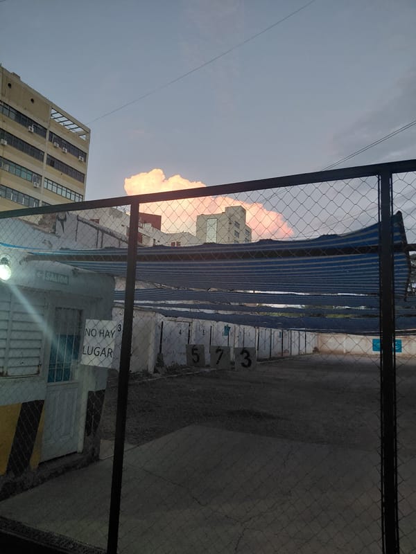 Chain-link fence view of multistory buildings in Mendoza