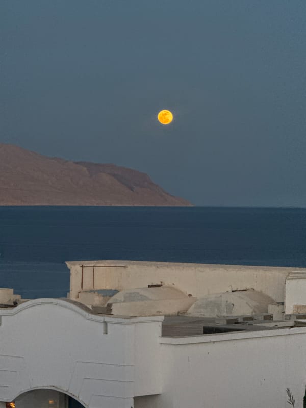 Woman smoking on balcony during full moon in Sharm El Sheikh