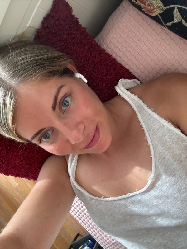 Woman rests on bed in Paris apartment