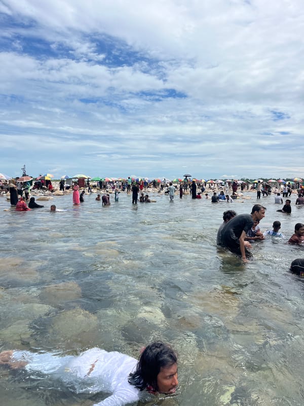 Crowds wade in River Titas during a riverside gathering in Majai