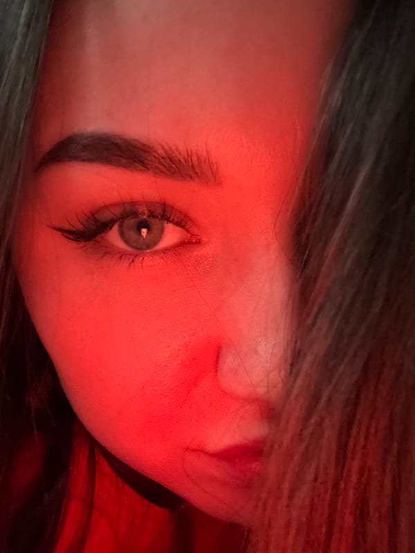 Person photographed with energy drink under red lighting