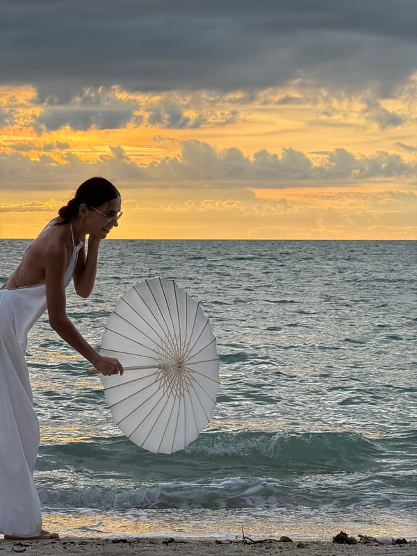 White dress, parasol, and a dramatic sunset at Baan Plai Laem