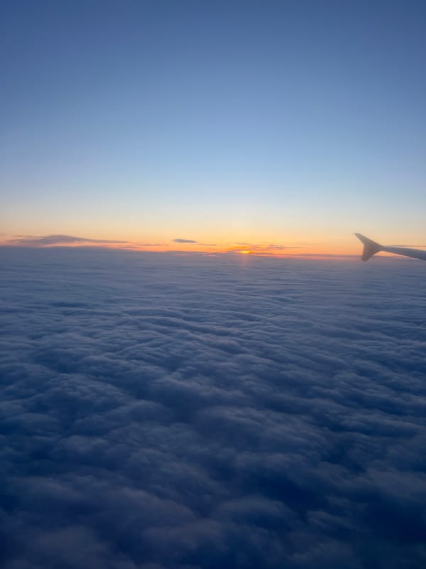 Airplane wing photographed from window over Moldova at sunset