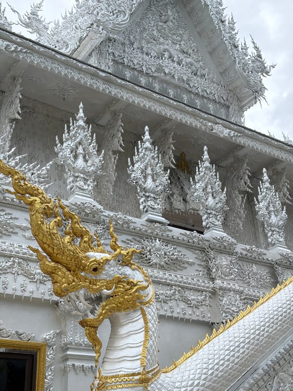 Visitor documents Thailand's White Temple from multiple angles during rainstorm
