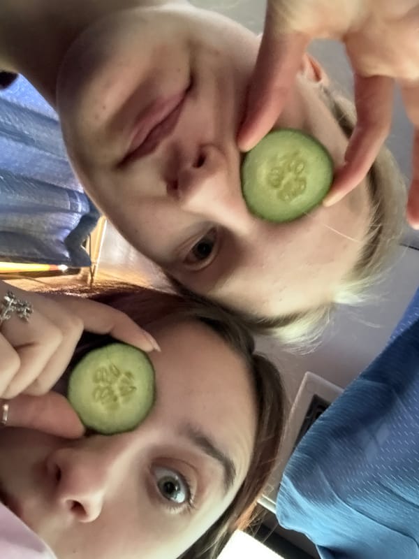 Two people pose with cucumber slices over eyes in Russia