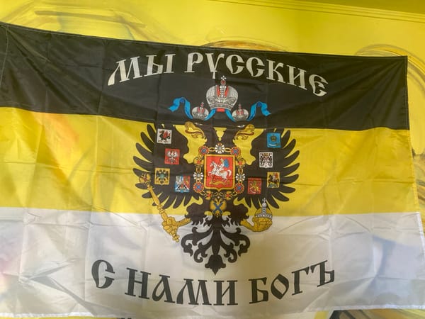 Mixed art display with abstract paintings and a Russian nationalist flag