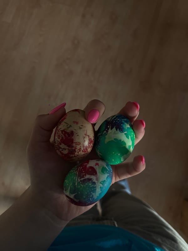 Person displays three decorated eggs in Bulgarian town