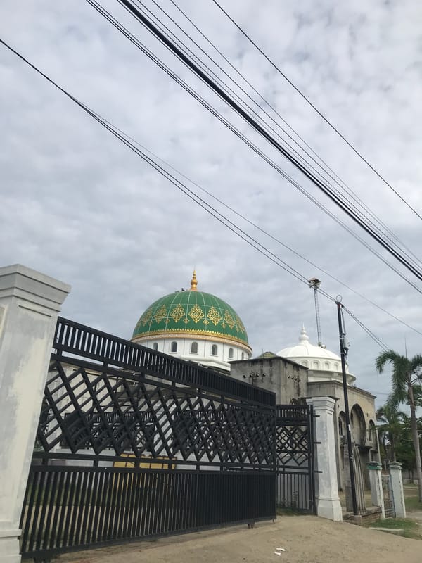Islamic Center Lhokseumawe mosque viewed through metal fence