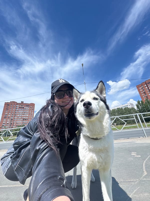 Woman takes morning selfies with husky in urban park