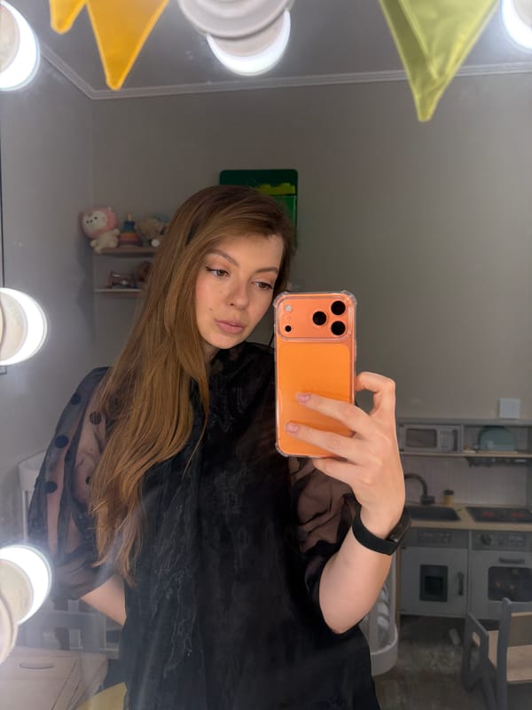 Woman Takes Selfie at Vanity Mirror with Orange Phone