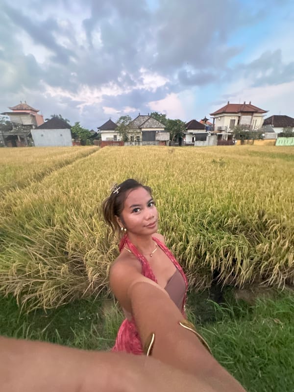 Woman films selfies in Indonesian rice fields as kites fly overhead