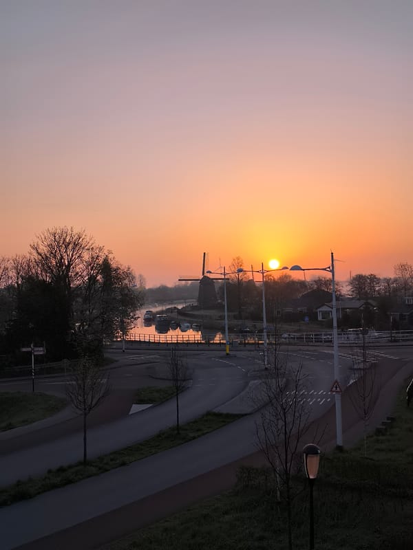 Sunrise illuminates windmill and canal in Alkmaar streetscape