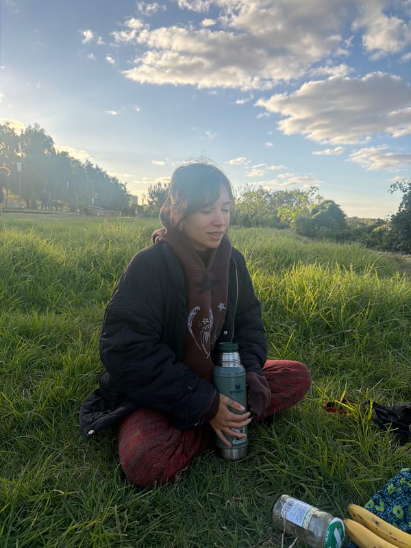 Person enjoys outdoor meal with thermos in Argentine field
